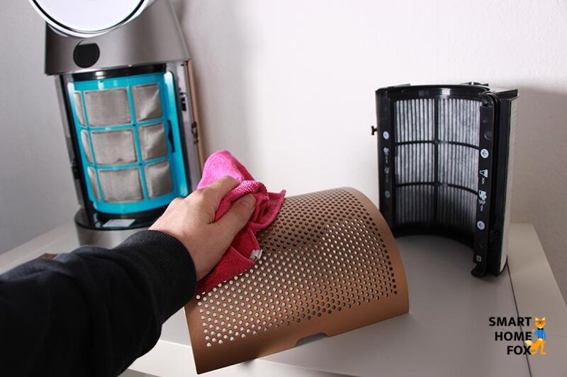 Das Luftgitter vom Dyson Purifier Cool Luftreiniger und Turmventilator liegt auf dem Tisch und wird mit einem Tuch gereinigt.